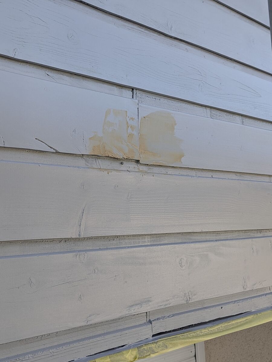 Détail d'une reprise à l'enduit fibré sur les lames de bardage avant mise en peinture